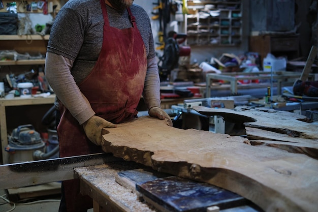 Foto o artesão marca a madeira com uma régua e um lápis. a precisão do artesanato alinha-se com o sob medida.