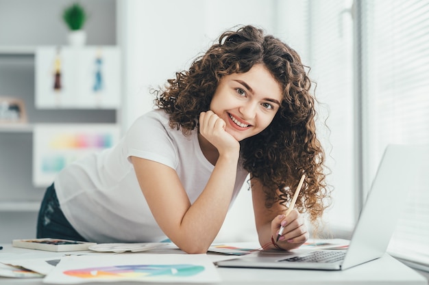 O artista feliz trabalhando com um laptop na mesa