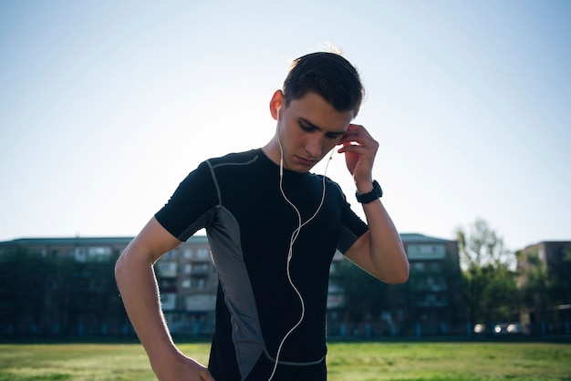 O atleta coloca fones de ouvido antes de correr