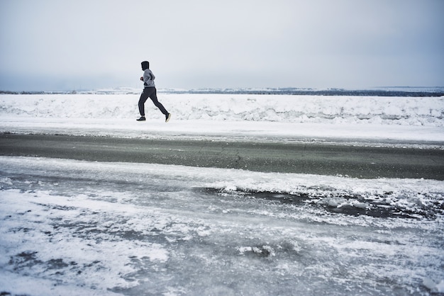 O atleta corre no inverno na estrada