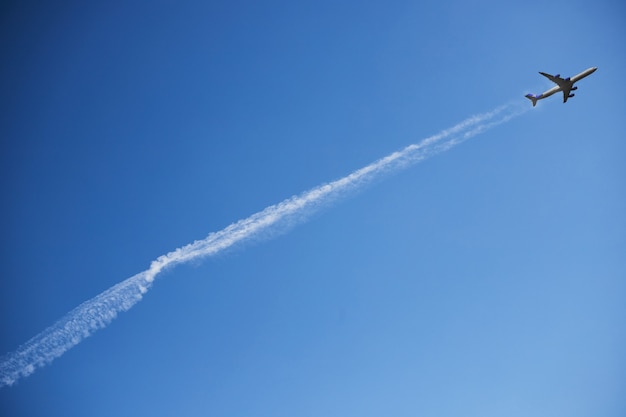 O avião no céu claro decola deixando a linha