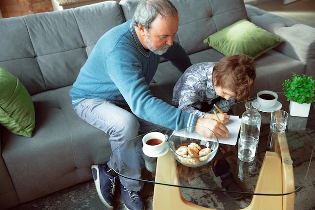 O avô e o neto passam o tempo isolados em casa, escrevendo, desenhando ou brincando