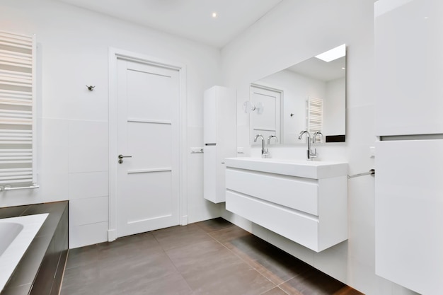 O banheiro é em estilo minimalista com uma cômoda branca