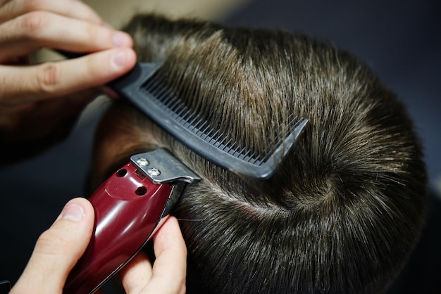 O Barbeiro faz o homem separar o cliente de um aparador elétrico em uma barbearia