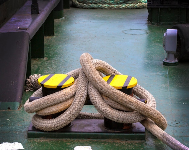 O barco ancorado amarrado com corda náutica e nó Fechar