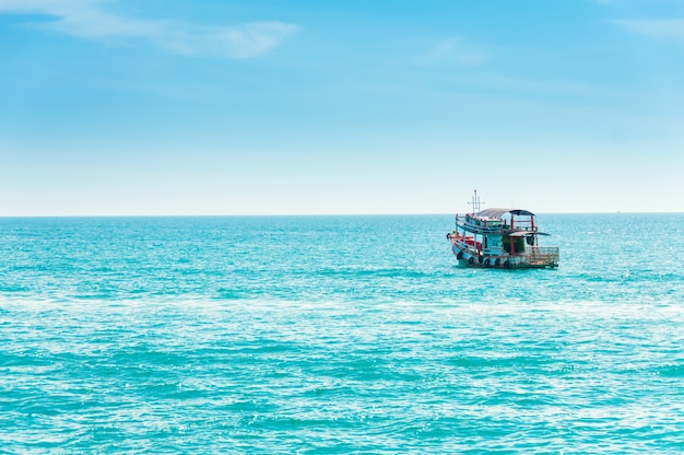 O barco de pesca navega no mar, que tem água limpa e limpa