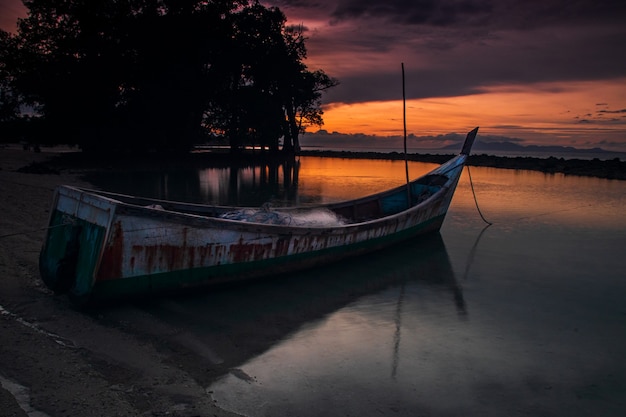 O barco está estacionado na praia de areia branca