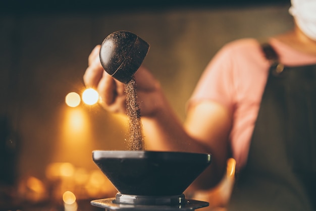 O barista profissional faz uma bebida fresca com chá e leite na xícara, bebida saborosa no bar café, mão segurando leite com leite em uma cafeteria ou restaurante de comida, barman trabalhando em uniforme de cafeteria