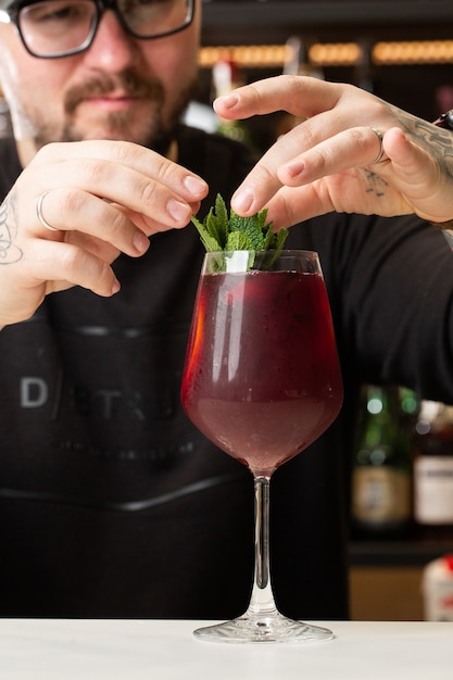 O barman fazendo sangria vermelha em um restaurante italiano coquetel de sangria com vinho tinto no bar borrado