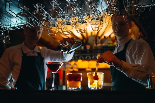 O barman prepara coquetéis no bar.