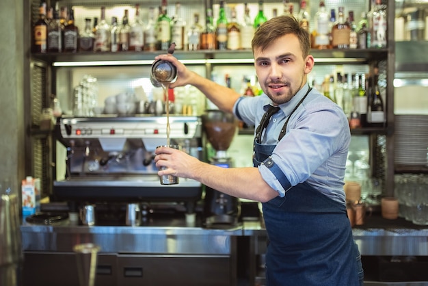 O bartender feliz trabalhando no bar