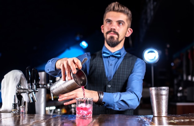 O bartender profissional dá os últimos retoques em uma bebida