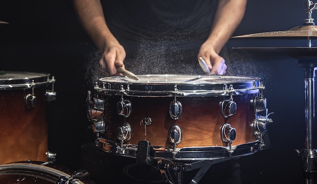 O baterista toca a caixa com salpicos de água.