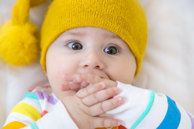 O bebê coloca as mãos na boca