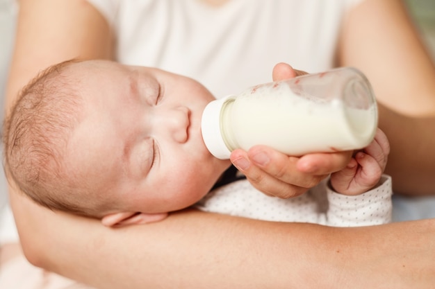 O bebê come leite da mamadeira e dorme