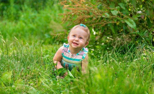 O bebê está sentado na grama. Foco seletivo. Natureza.