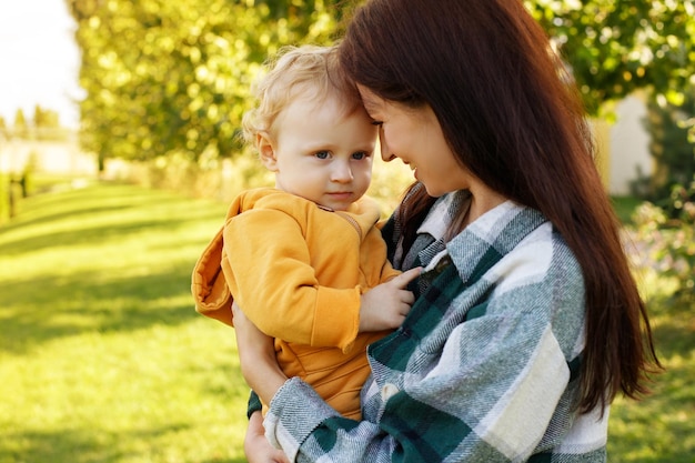 O bebê está triste nos braços de sua mãe para passear