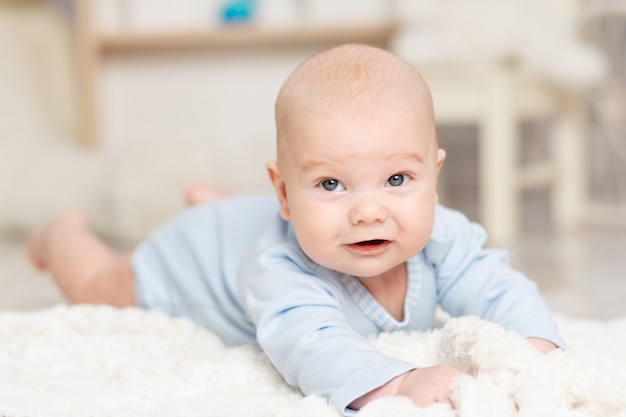 O bebê fica em casa no quarto das crianças com brinquedos, conceito de desenvolvimento e jogos