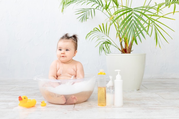 O bebê lava em uma tigela com espaço de espuma para texto sobre a higiene do bebê de mamadeiras