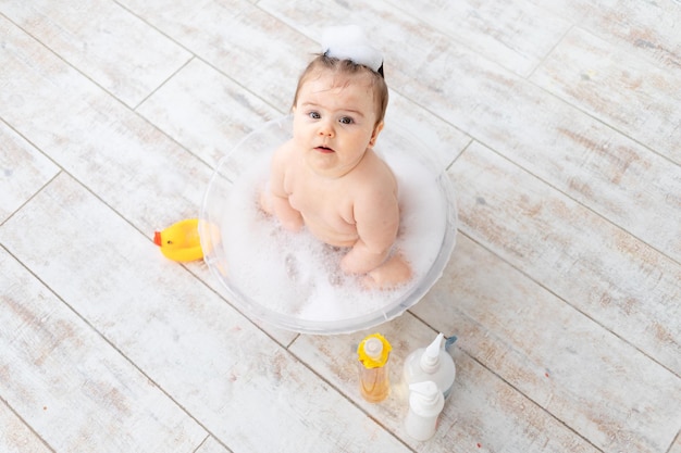 O bebê lava em uma tigela com espaço de espuma para texto sobre a higiene do bebê de mamadeiras