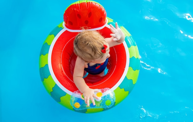 O bebê nada em círculo na piscina. foco seletivo.