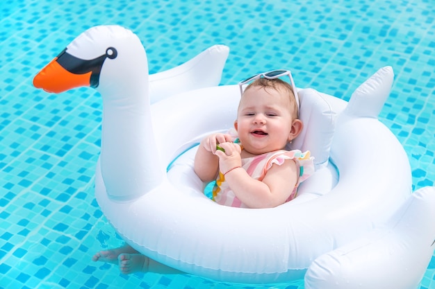 O bebê nada em círculo no mar. Filho.