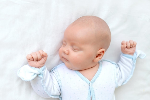 O bebê recém-nascido dorme sete dias em um berço em casa em uma cama de algodão closeup