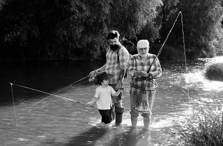 Foto o bisavô e o bisneto a pesca tornou-se uma atividade recreativa popular. pai e neto felizes com varas de pesca no cais do rio.