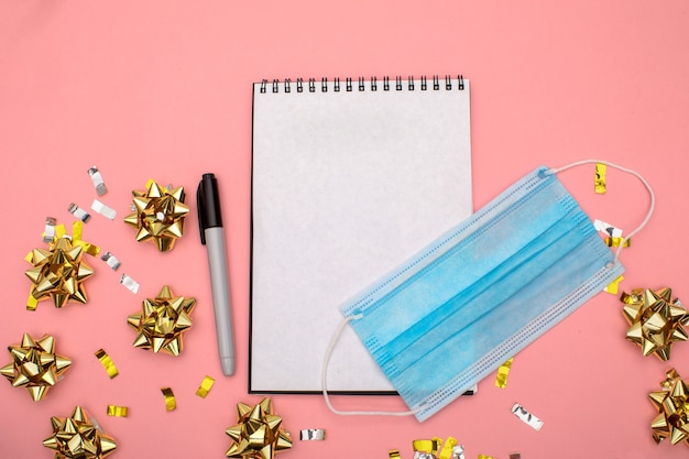 O bloco de notas da lista de desejos com marcador encontra-se sobre um fundo azul com confetes dourados