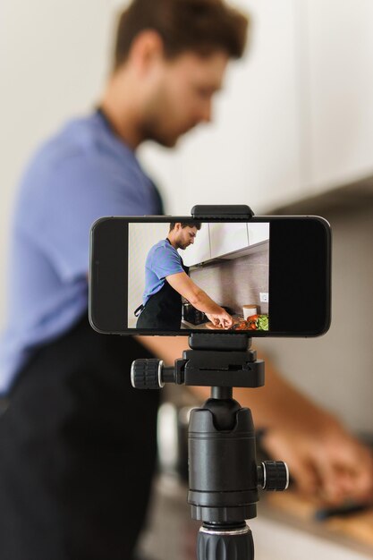 Foto o blogueiro do chef está cozinhando na cozinha