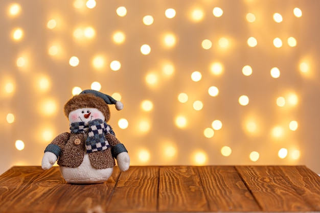 O boneco de neve do trenó do relógio da árvore de Natal vela presentes em um fundo de madeira e luzes de fundo