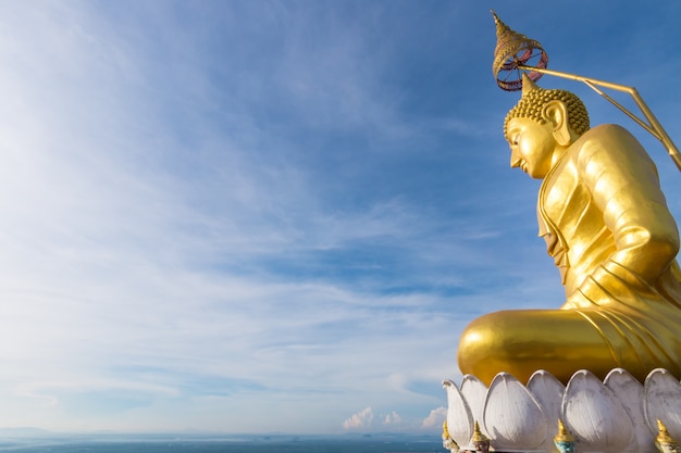 O Buda dourado no topo da montanha, templo da caverna do tigre, Krabi, Tailândia