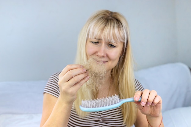 O cabelo da mulher está caindo Foco seletivo