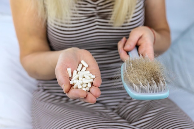 O cabelo de uma mulher cai vitaminas Foco seletivo