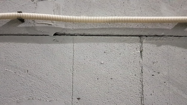 O cabo elétrico é colocado em uma corrugação protetora sobre a parede. fios elétricos são carregados na parede para conectar soquetes e interruptores.