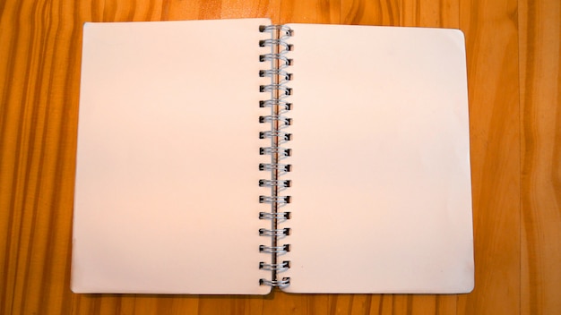Foto o caderno na tabela de madeira na cafetaria.