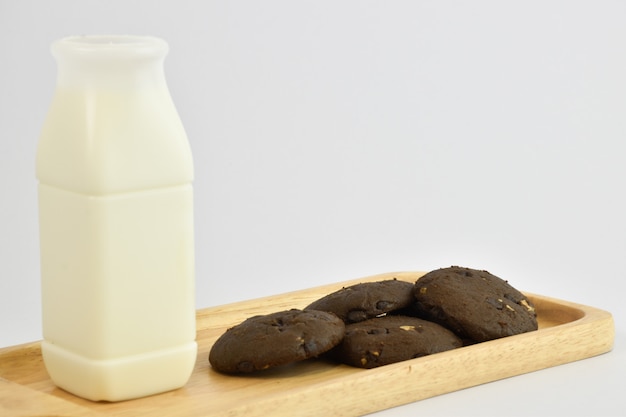 Foto o café da manhã inclui cookies do leite e do chocolate em um fundo branco.