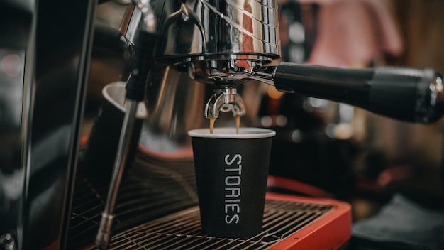 O café está sendo enchido no copo e pronto para ser bebido.