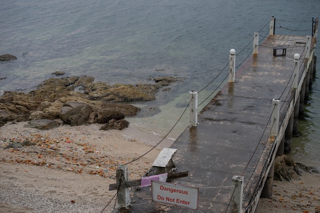 O cais velho fica ao lado do mar calmo. É um lugar perigoso para entrar.