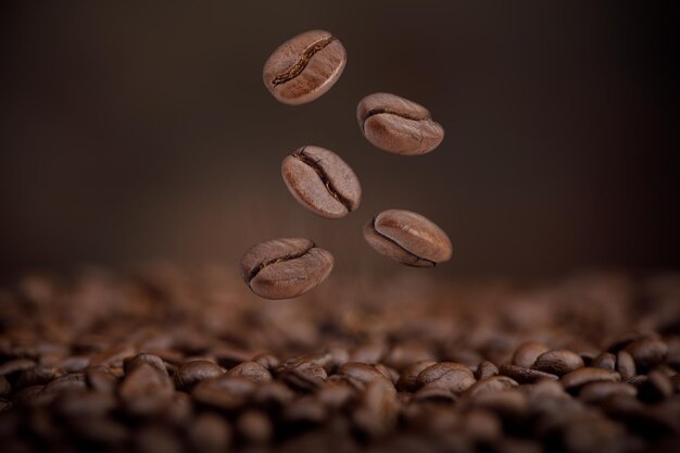 O calor de grãos de café torrados castanhos caindo do ar em fundo castanho Produtos saudáveis por conceito de ingredientes naturais orgânicos