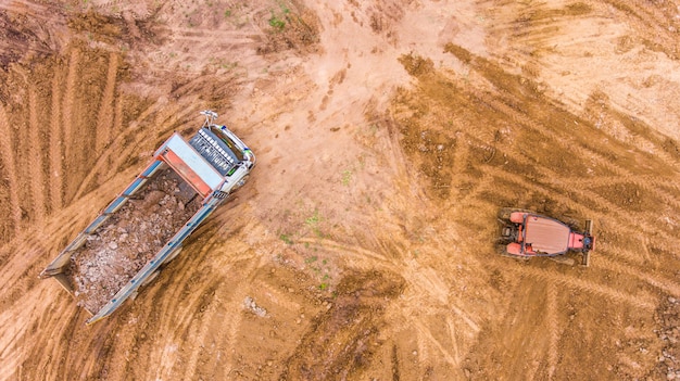 O caminhão descarrega o solo no canteiro de obras. Vista aérea