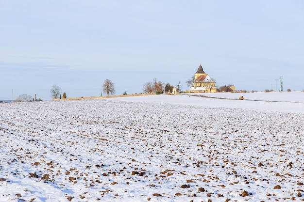 O campo está coberto de neve, não caiu muita neve. Inverno frio. Foco suave.