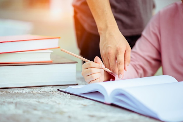 O campus de jovens estudantes ajuda os amigos a aprender. Conceito de pessoas, aprendizagem, educação e escola.