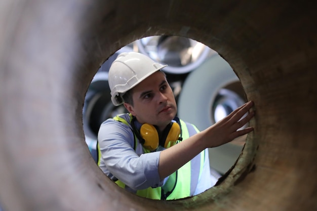 O capataz ou trabalhador trabalha no local da fábrica verifica a máquina ou os produtos no local Engenheiro ou técnico verificando o material ou a máquina na planta industrial e na fábrica