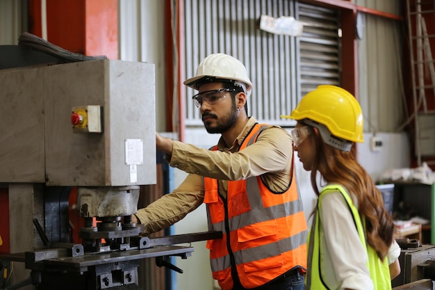 O capataz ou trabalhador trabalha no local da fábrica verifica a máquina ou os produtos no local Engenheiro ou técnico verificando o material ou a máquina na planta industrial e na fábrica