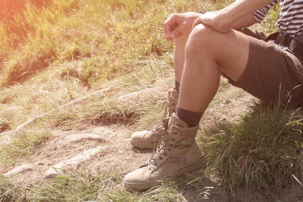 O cara com botas de caminhada bege. fechar-se