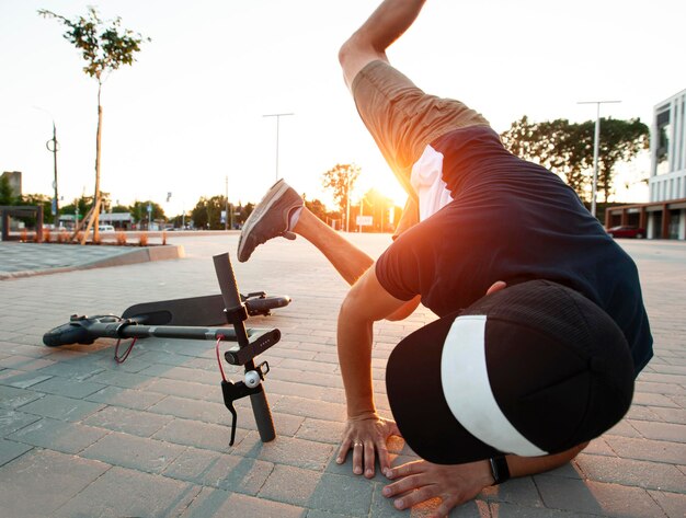 O cara está caindo da scooter elétrica no caminho