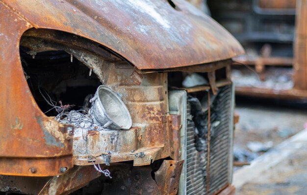 O carro foi completamente destruído pelo fogo carro queimado e enferrujado abandonado pela estrada carros estavam em chamas no estacionamento guerra da rússia contra a ucrânia estilhaços e buracos de bala nos carros