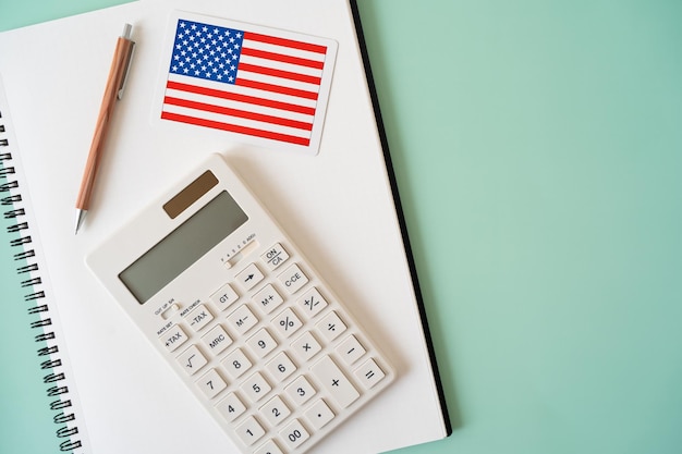 O cartão da bandeira americana, a calculadora, a caneta e o caderno.