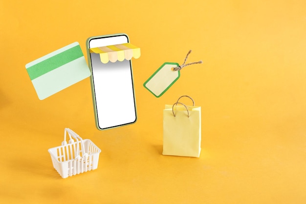O cartão de crédito da cesta de compras e a sacola flutuando para fora da loja online em um fundo amarelo